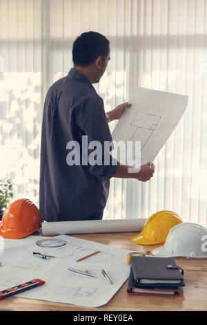 Architect working in a office. Engineer holding blueprint in office, architectural concept Stock Photo
