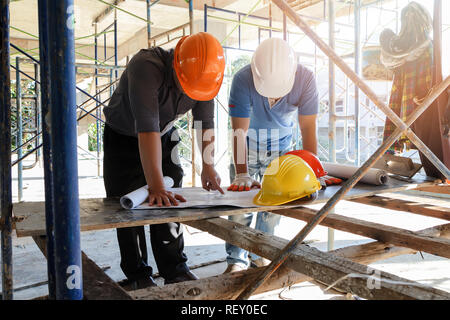 Engineer discussing with foreman about project in building construction site Stock Photo
