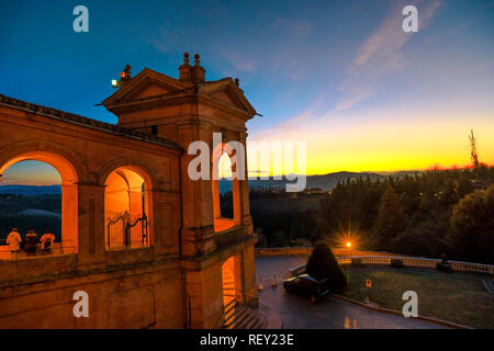 Side view of Sanctuary of Blessed Virgin of San Luca and Colle della Guardia above city of Bologna at illuminated at twilight. Famous pilgrinage place in Emilia-Romagna, Italy. Stock Photo