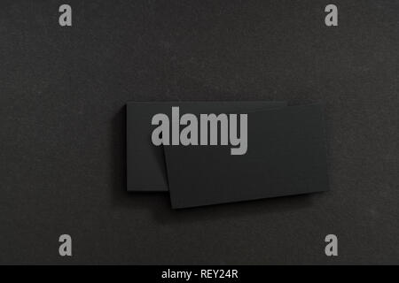 Photo of black blank business cards on a black background. Template for ID. Top view Stock Photo