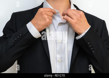 Closeup of businessman in formal suit correcting a shirt Stock Photo