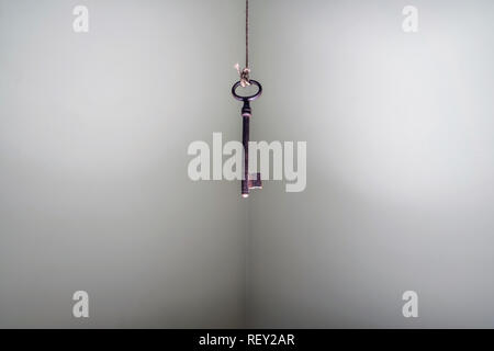 Looking up at old key hanging on string. Business success freedom concept concept for aspirations, achievement and incentive Stock Photo