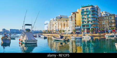 ST JULIANS, MALTA - JUNE 20, 2018: Panorama of the city with numerous power boats and George Borg Olivier street, reflected in calm waters of Spinola  Stock Photo