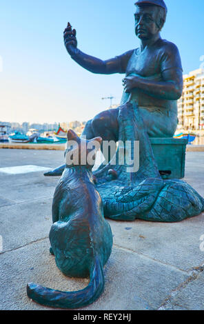 ST JULIANS, MALTA - JUNE 20, 2018: The modern statue of the fisherman and cat at Spinola Bay is the main landmark of the seaside promenade, on June 20 Stock Photo