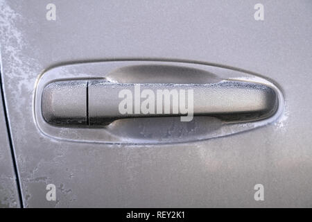 Car door handle covered in frost on early autumn morning. Dropping temperature approaching winter, ice crystals Stock Photo