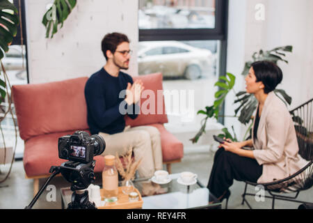 close up photo. young talented journalist asking some questions to a male writer Stock Photo