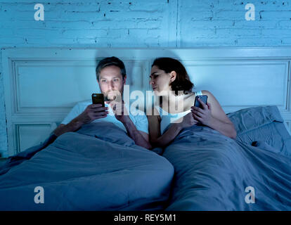 Lifestyle of mobile addicted man husband and angry frustrated wife woman feeling ignored and upset in Internet, Social media Games and Technology addi Stock Photo