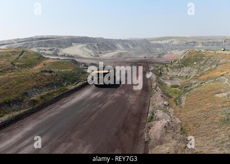 A large coal mining truck hauls coal inside of a vast open pit coal mine in the Powder River Basin of Wyoming, USA. Stock Photo