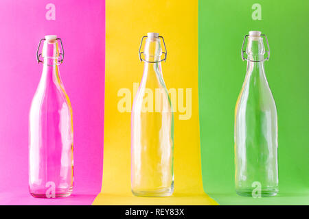 Three Empty Glass Bottles on Multicolored Background Stock Photo