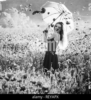 girl in field of poppy seed with umbrella Stock Photo