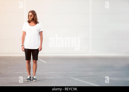 Young man with beard and long hair standing Stock Photo