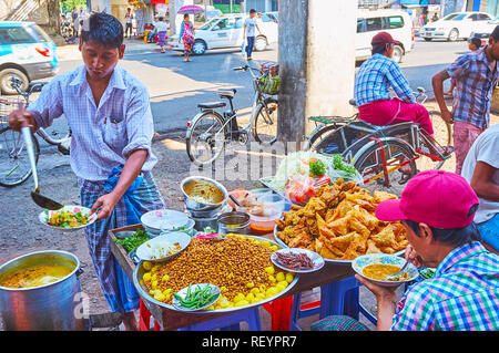 YANGON, MYANMAR - FEBRUARY 17, 2018: The roadside food stalls in Chinatown are very popular among the rickshaws, drivers, market vendors, porters and  Stock Photo