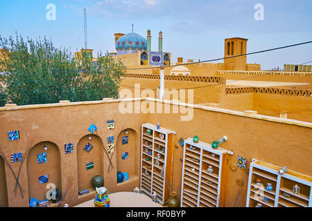 YAZD, IRAN - OCTOBER 18, 2017: The roof of Yazd Art House overlooks court of handicraft center, adobe edifices and splendid Imamzadeh Sayyed Fathoddin Stock Photo