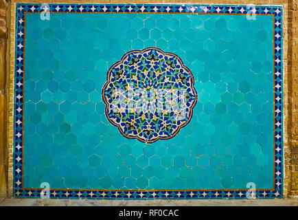 Bright blue decorative panel on wall of Jameh Mosque with ornate mosaic rossette in the middle of azure field, Yazd, Iran. Stock Photo