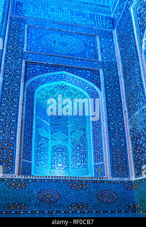 Detail of the entrance portal of Jameh Mosque - bright blue illuminated wall with intricate tile Azari style ornaments, Yazd, Iran. Stock Photo