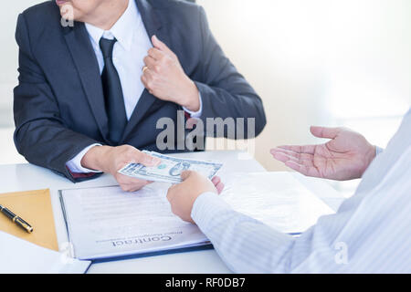 Businessman or politician taking bribe and Shaking Hands With Money in a suit, corruption trade exchange concept Stock Photo