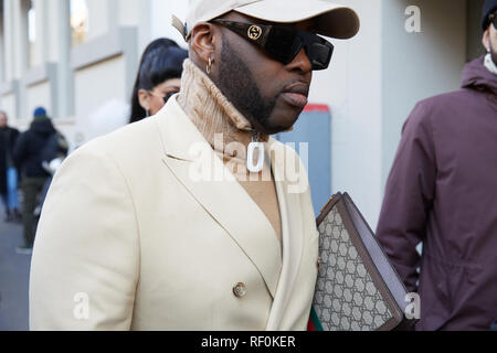 MILAN, ITALY - JANUARY 13, 2019: Man with Gucci sunglasses and bag and beige turtleneck before John Richmond fashion show, Milan Fashion Week street s Stock Photo
