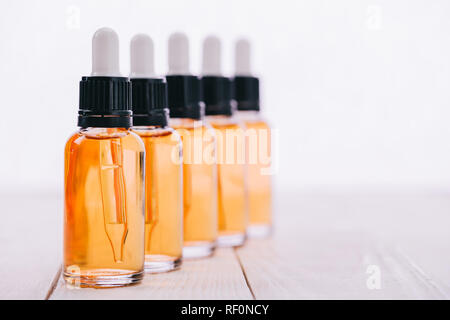 selective focus of cbd oil in bottles with droppers on wooden surface isolated on white Stock Photo