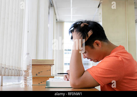 Guys are stressed with studying. Read books in the library, and use the ideas to review the content. Concerned about what will happen. Handles on the  Stock Photo