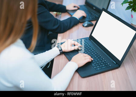 The girl works at a laptop in the office. Hands with laptop close up. Stock Photo