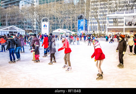 New York City, NY / USA - 12 23 2013: People are enjoying ice skating at Bryant park Midtown Manhattan in front of the New York Public library Stock Photo