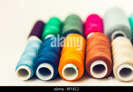Colored sewing thread coils on white background with copy space for text Stock Photo