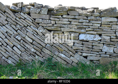 Dry stone wall with a mixture of level and sloping courses on the Isle of Purbeck, Dorset. Rough limestone wall divides coastal fields. Stock Photo