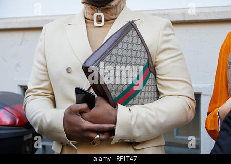 MILAN, ITALY - JANUARY 13, 2019: Man with Gucci leather bag and beige jacket before John Richmond fashion show, Milan Fashion Week street style Stock Photo