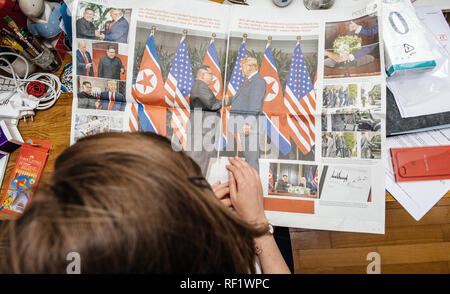 PARIS, FRANCE - JUNE 13, 2018: View from above of woman reading big article about U.S. President Donald Trump meeting North Korean leader Kim Jong-un in Singapore in German Die Welt  Stock Photo