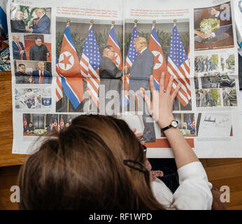 PARIS, FRANCE - JUNE 13, 2018: View from above of woman reading big article about U.S. President Donald Trump meeting North Korean leader Kim Jong-un in Singapore in German Die Welt  Stock Photo