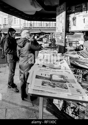 LISBON, PORTUGAL - FEB 10, 2018: People shopping for international newspapers on kiosk in central Lisbon street - black and white Stock Photo