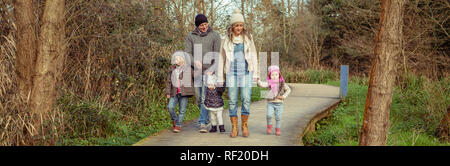 Happy family walking together holding hands in the forest Stock Photo