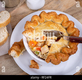 Overhead view of a chicken pot pie with vegetables and golden crust in a bowl Stock Photo