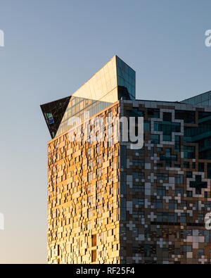 Birmingham, UK - January 22 2019: The Cube in central Birmingham catching the golden hue of the morning winter sun, highlighting patterns on its side. Stock Photo