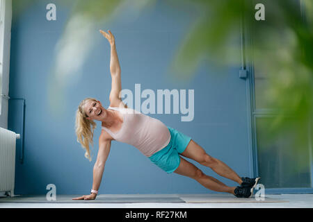 Happy pregnant woman practicing yoga Stock Photo