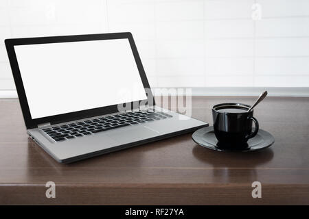 Laptop with empty blank screen on wooden tabletop with modern blur kitchen background. Product display concept. Stock Photo