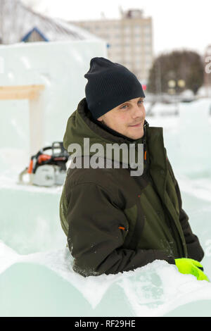 Portrait of a worker at an assembly site of an ice town in winter overalls Stock Photo