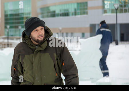 Portrait of a worker at an assembly site of an ice town in winter overalls Stock Photo