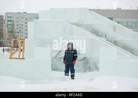 Portrait of a worker at an assembly site of an ice town in winter overalls Stock Photo