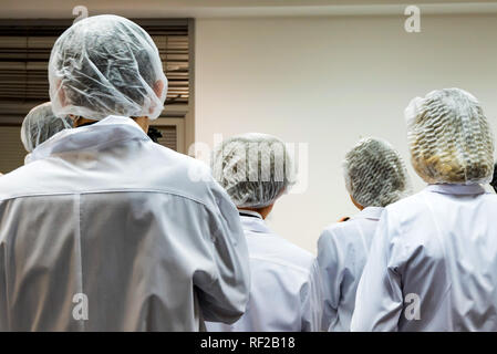 Food factory workers in uniform back view Stock Photo