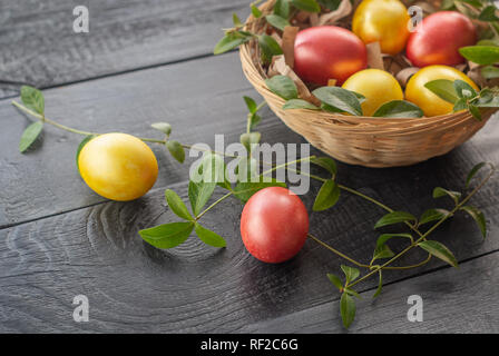 Easter eggs in a wicker basket on a wooden background. Happy Easter. Stock Photo