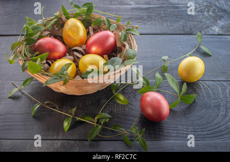 Easter eggs in a wicker basket on a wooden background. Happy Easter. Stock Photo