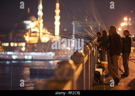 Fishermen at Galata Bridge over the Golden Horn, two-storied road bridge, traffic above, bars and restaurants below, Istanbul Stock Photo