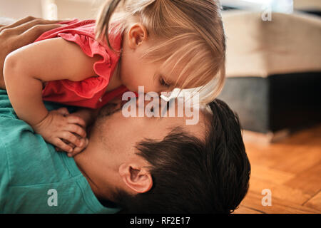 Father and little daughter cuddling together at home Stock Photo