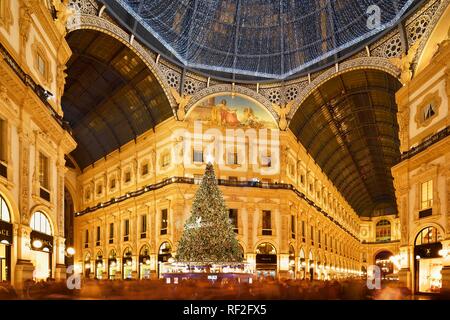 People marvel at Christmas tree and Christmas lights in luxury shopping arcade, covered gallery Galleria Vittorio Emanuele II Stock Photo