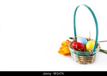 Colorful easter eggs in a basket and tulips isolated on white background. Copyspace Stock Photo