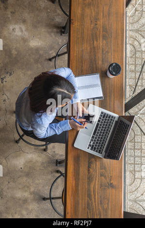 High angle view of Asian woman working on smartphone Stock Photo