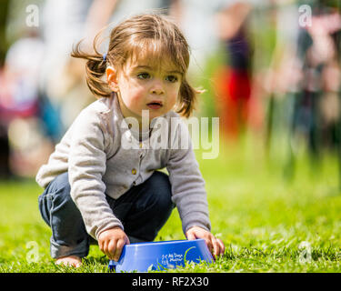 A little girl holding a dog bowl at the Hampstead Heath dog show. Stock Photo