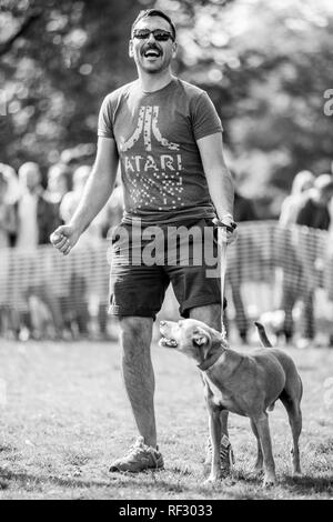 A man with his dog celebrating a win in a dog show Stock Photo