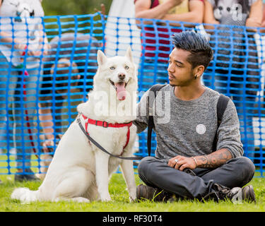 A young man with his beautiful dog in the park at a dog show Stock Photo